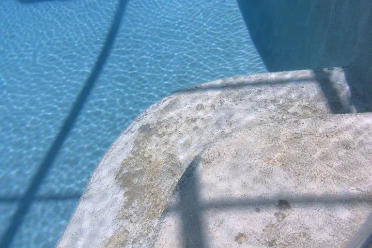 Rough pool plaster step needing resurfacing